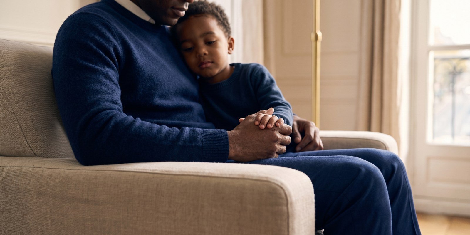 Un parent tenant la main de son enfant, moment de réconfort au sein du foyer